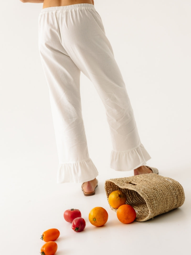 Białe letnie spodnie damskie z lnu z szerokimi nogawkami - widok na falbanki na nogawkach