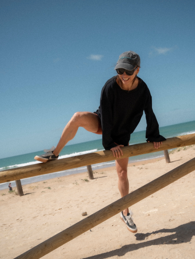 Czarna koszulka damska z długimi rękawami o luźnym kroju i z nadrukiem - letni plażowy outfit z krótkimi szortami