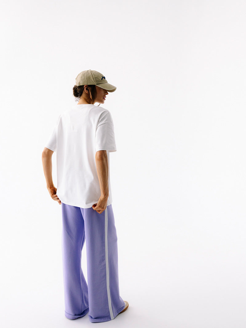 Jasna bawełniana koszulka oversize Pilates Club - widok na plecy, zestaw z lawendowymi szerokimi spodniami