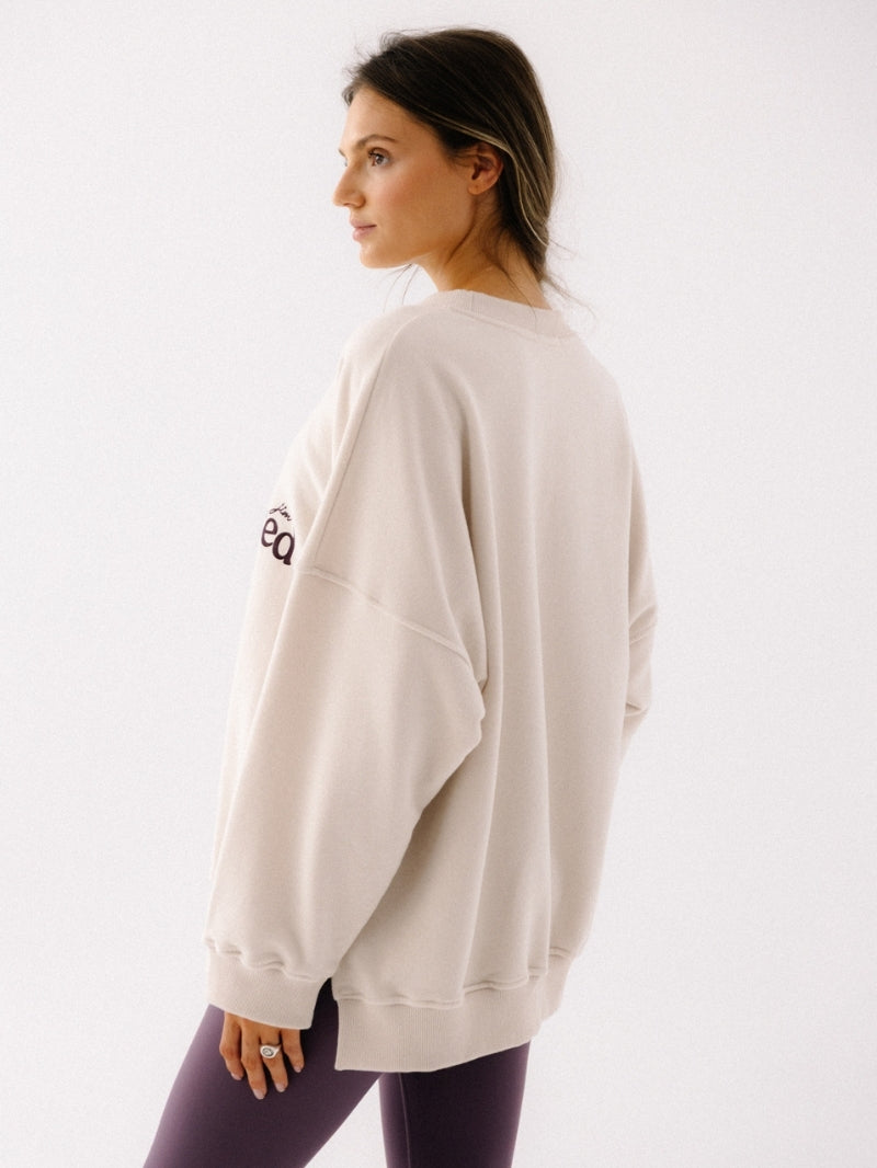 Kremowa luźna bluza z nadrukiem yoga obsessed - widok na szerokie rękawy