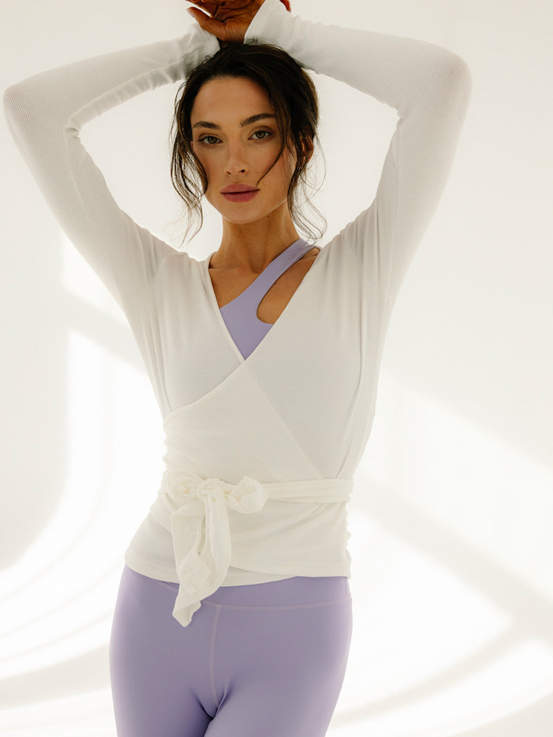 Kremowy kopertowy sweter wiązany Glow Up - wersja zawiązana z fioletowym topem i legginsami