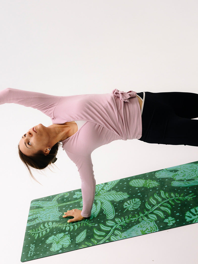 Zielona, składana mata do ćwiczeń jogi z kauczuku 1 mm z tropikalnym wzorem - joginka podczas ćwiczeń